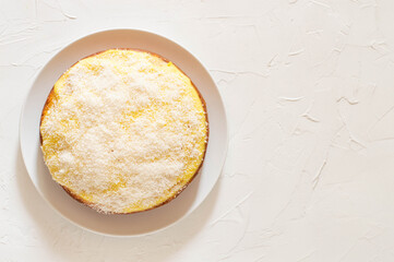 Sponge cake with cream on top and coconut flour. White background