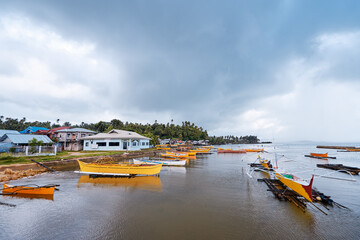 Traditional fishing boats harbour at rainy day. Siargao, Philippines.