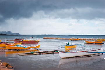 Fototapeta premium Tropical fishing boats harbour at rainy day. Siargao, Philippines.