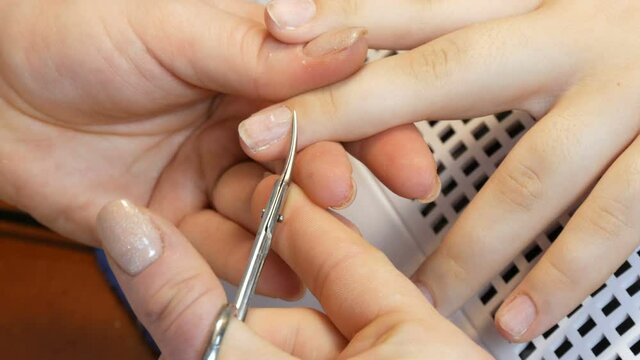 Manicure scissors trim the cuticles on the nails at home