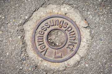 Survey point of metall on street in german word