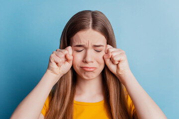 Fototapeta premium Portrait of desperate abused offended girl cry fists face on blue background