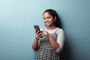 Happy young girl looking on a smart phone 