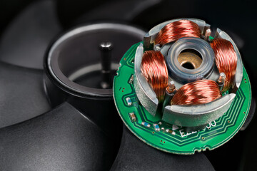 Closeup of inductors on stator and rotor with permanent magnet and black blades in background....