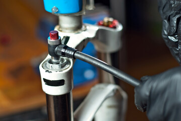 The master inflated the bicycle frame. Pump and male hands close up.