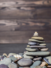 Multi-colored oval pebbles one on top of the other make up a group. Sea pebble pyramid. Pebble mini-house. Stack of pebbles for spa, balance, meditation and zen themes. Pebble background and texture
