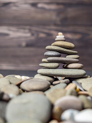 Multi-colored oval pebbles one on top of the other make up a group. Sea pebble pyramid. Pebble mini-house. Stack of pebbles for spa, balance, meditation and zen themes. Pebble background and texture