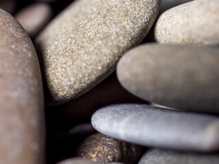 Multi-colored wet pebbles on the shore close-up. Various shapes of stones. Unusual stones. Macrocosm. Pebble background. Shore. Beach. Pebble texture