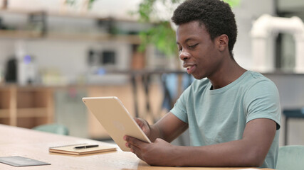 Serious Professional Young African Man using Tablet