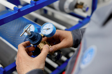 A metrology laboratory specialist takes a compressed gas cylinder for testing and verification. The...