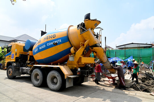 BANGKOK, THAILAND - May 4, 2021 : Many Thai Construction Workers is mixing cement and loading cement from cement truck to build houses. Construction Concept in Thailand.