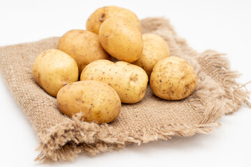 Fototapeta na wymiar Fresh organic potatoes on sackcloth rag. Raw potato.