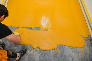 Worker applying epoxy and polyurethane flooring system