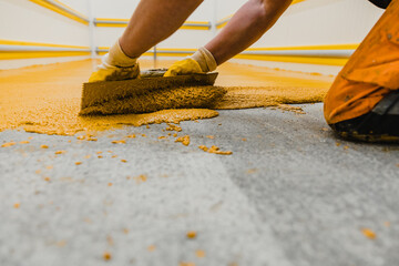 Worker applying epoxy and polyurethane flooring system
