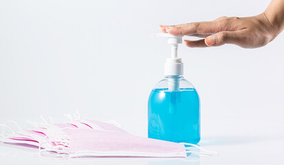 Human hand, alcohol and mask on white background.
