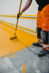 Worker applying epoxy and polyurethane flooring system