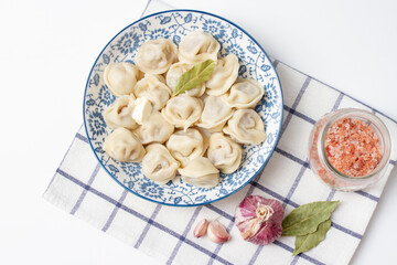 Dumplings in a blue plate on a checkered towel