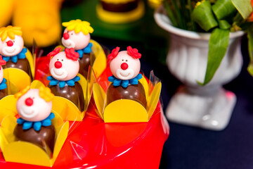 Table with sweets and muffins decorated with Royal icing at a children's party.