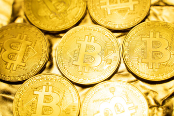 Golden bitcoin Coins on a golden background. Trading on the cryptocurrency exchange. Cryptocurrency Stock Market Concept. Virtual money concept. Mining or blockchain technology. Business concept.