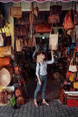 Travel and shopping. Young traveling woman with choose presents in bag shop in Morocco.