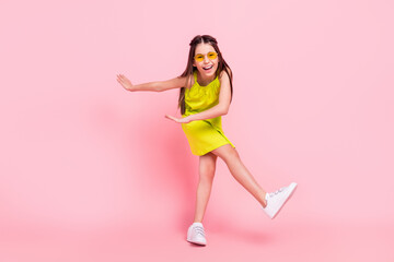 Full length photo of adorable pretty schoolgirl dressed yellow outfit dark glasses dancing smiling...