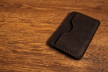 Leather card holder on a wooden background 
