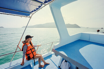 Portrait of young woman on the fishing yacht enjoying the seaview.