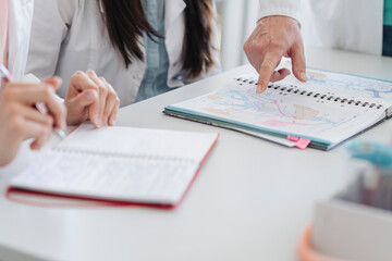Crop view of finger pointing at notes in notebook in science class