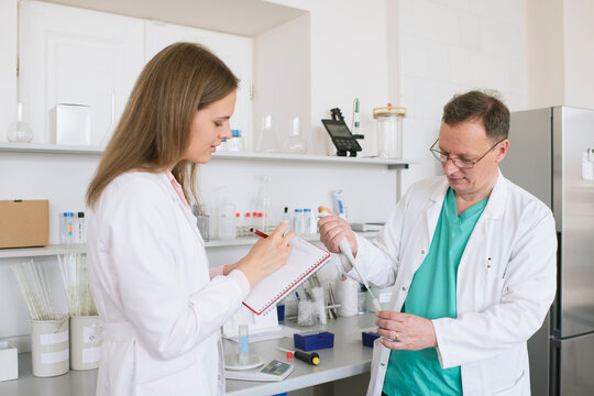 Researchers in white coats working in lab