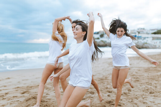 Cheerful female friends having fun at beach during vacations