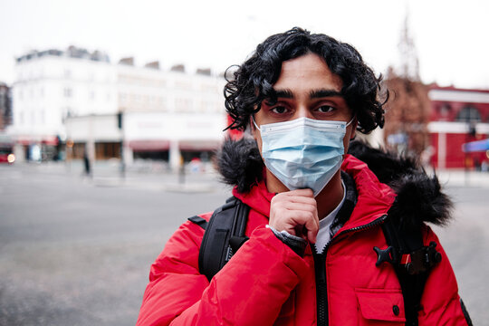 Young man in padded jacket wearing protective face mask during COVID-19