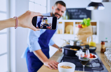 Portrait of handsome man filming cooking show or blog