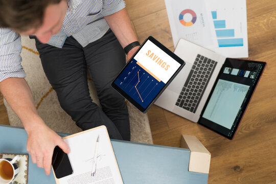 Businessman with digital tablet sitting with laptop while working at home