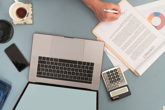 Businessman signing contract document on table at home