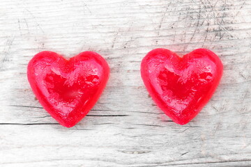 Two red hearts on natural wooden background as loving heart symbol for wedding greeting card with heart symbol or Valentine's Day card with beautiful red hearts