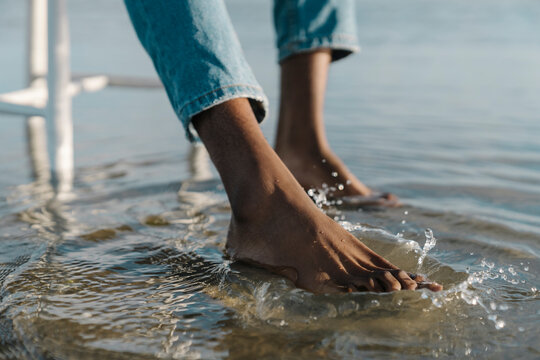 Man splashing water while sitting on white stool at beach