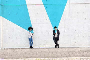 Graphic visualization of facial recognition effects covering man and woman using smart phones outdoors