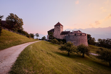 Fototapeta na wymiar Vaduz Castle, the official residence of the Prince of Liechtenstein, with Alps mountains in background on sunset.