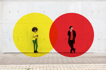 Two overlapping circles visualizing social distancing covering man and woman standing outdoors with smart phones in hands