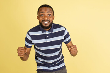 Fototapeta premium One African young man posing isolated over yellow studio background with copyspace for ad