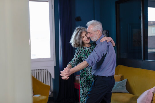 Senior couple dancing while standing at home