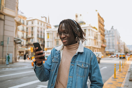 Smiling Man Using Phone In City