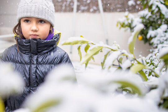 Girl child in warm clothing during snowfall