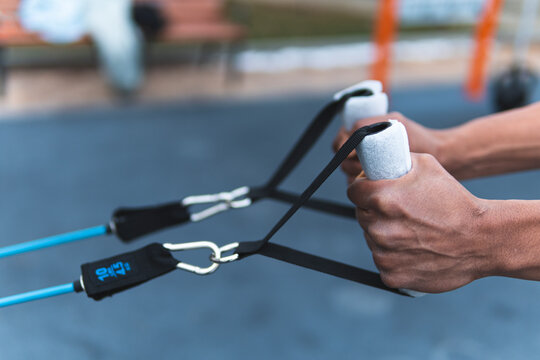 Sportsperson pulling resistance band while exercising outdoors