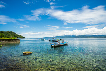 Obraz premium Traditional wooden boats with the fisherman in the Beautiful Amahusu Beach in Ambon, Maluku, Indonesia.