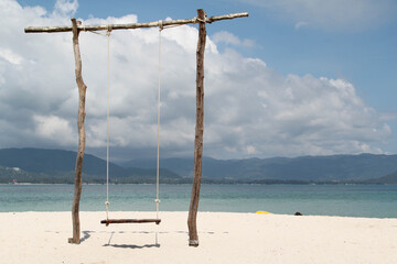 Obraz na płótnie Canvas The wooden swing on the beach.