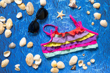 accesories for summer sea beach on blue wawes background. Beach things sunglasses and swim suit