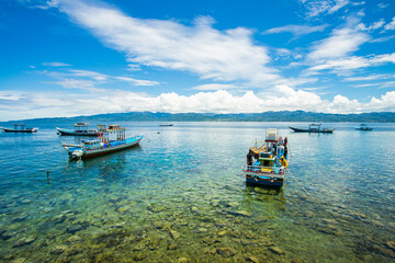 Traditional wooden boats with the fisherman in the Beautiful Amahusu Beach in  Ambon, Maluku,...