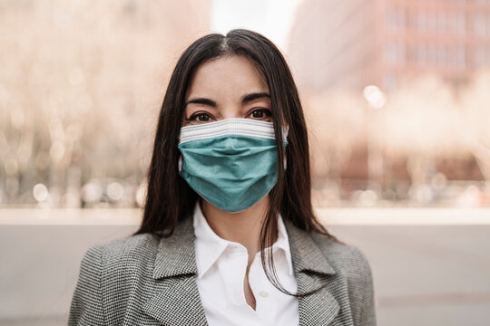 Businesswoman with protective face mask in city during COVID-19
