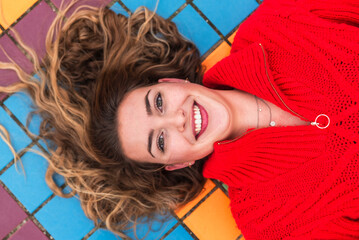 Happy woman lying on multi colored tiled floor